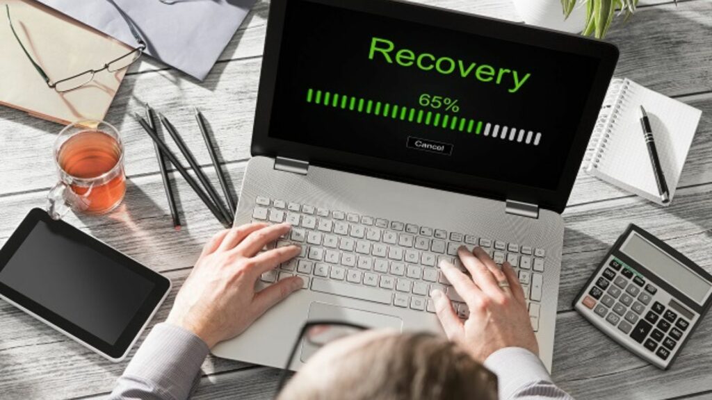 a man using a laptop written recovery showing the best ways to recover data